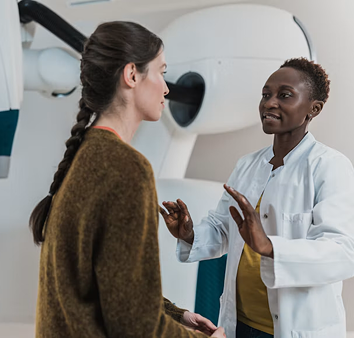 A clinician talking with a colleague next to imaging equipment